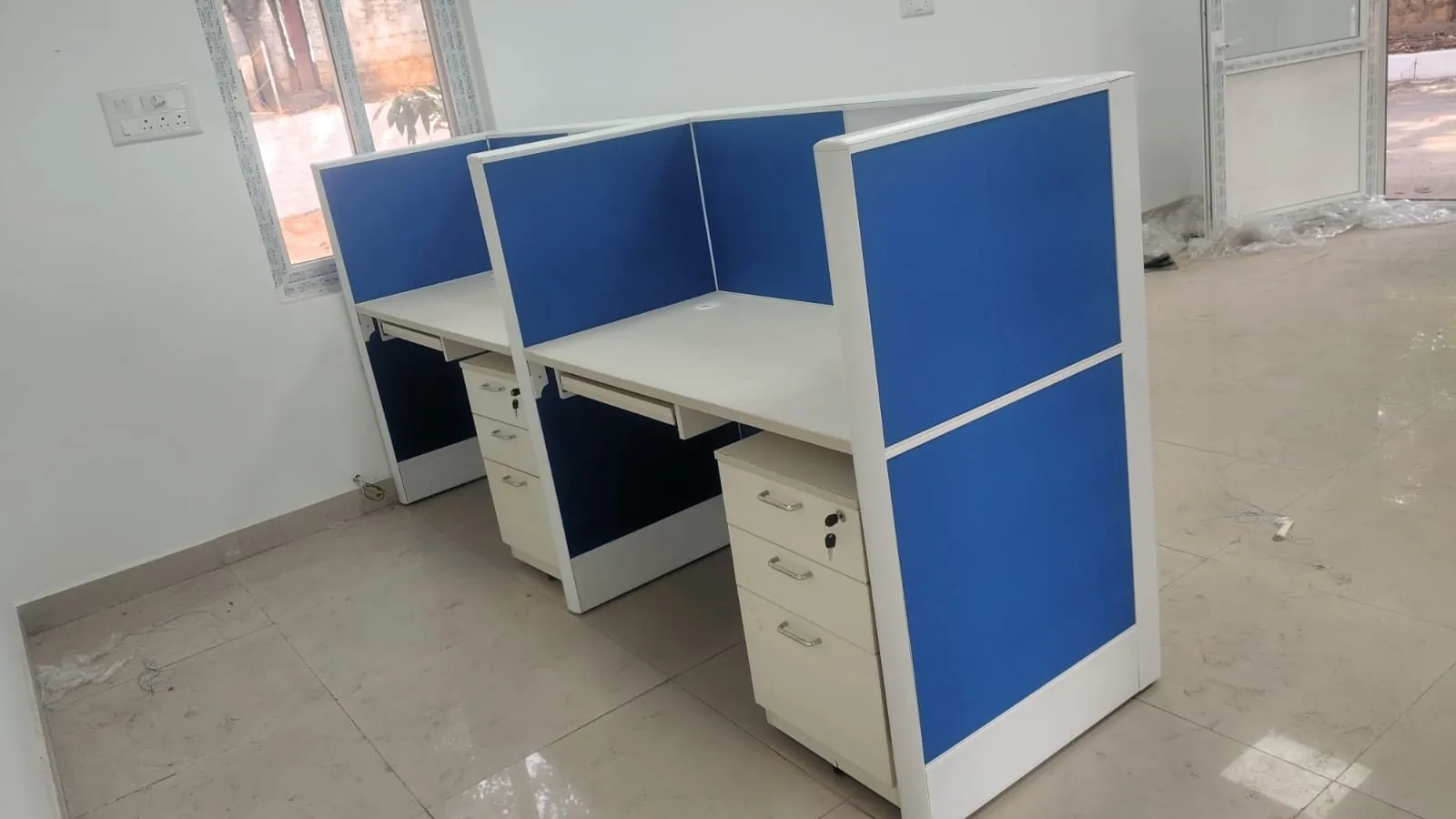 Row of screened modular workstations with keyboard trays and mobile pedestals